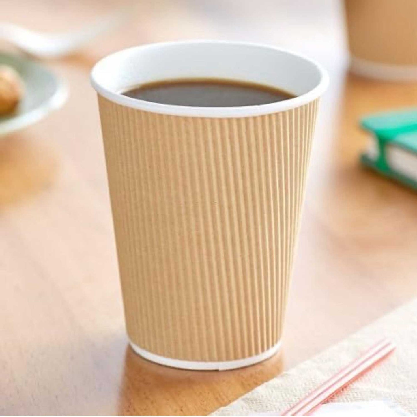 Brown paper cup with white rim on a wooden surface