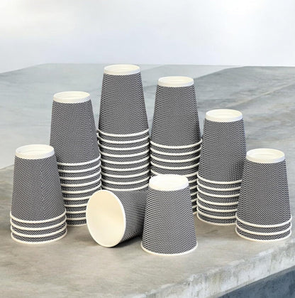 Stacks of black and white patterned paper cups on a gray surface