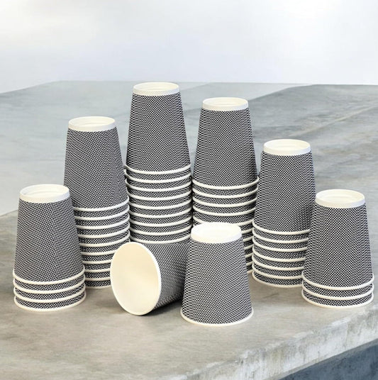 Stacks of black and white patterned paper cups on a gray surface