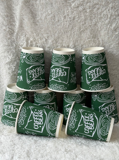 Green paper cups with 'Coffee Beans' text on a gray background