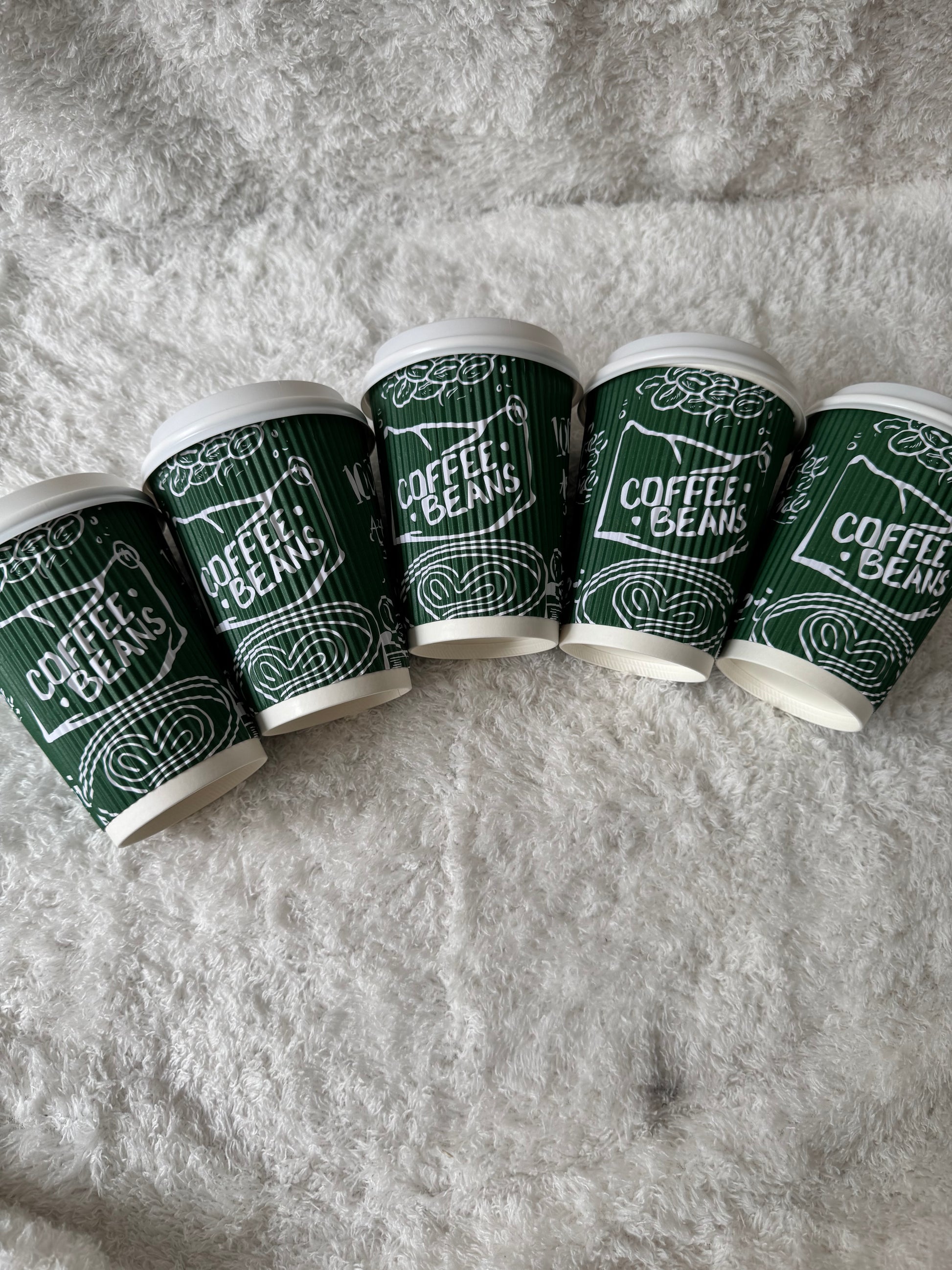 Green coffee bean packaging with white text on a gray textured background