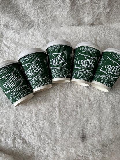 Green coffee bean packaging with white text on a gray textured background